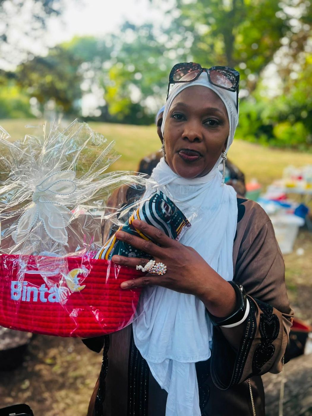 A member holding a gift hamper wrapped in cellophane