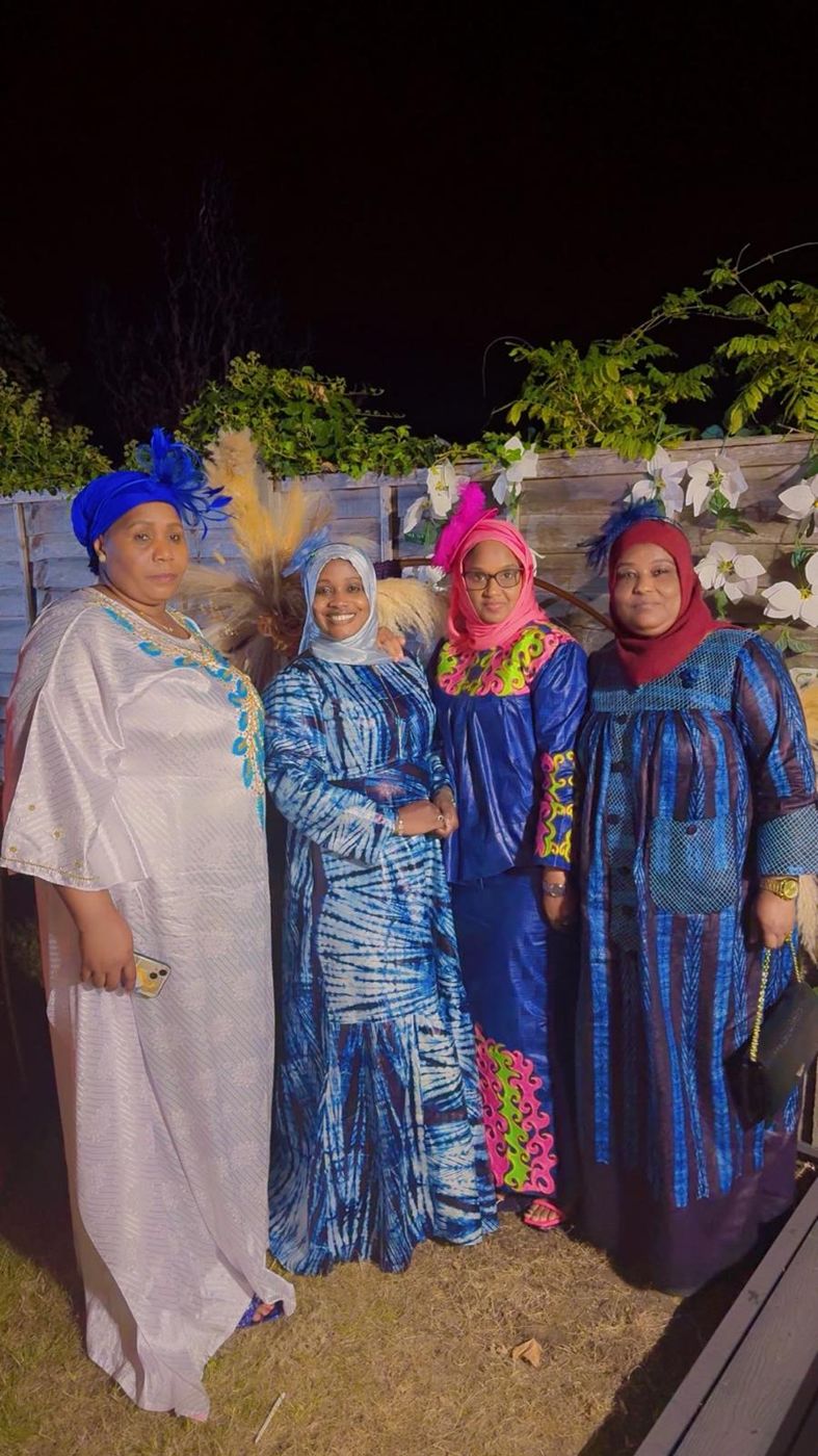Four members in traditional dress at an evening garden event