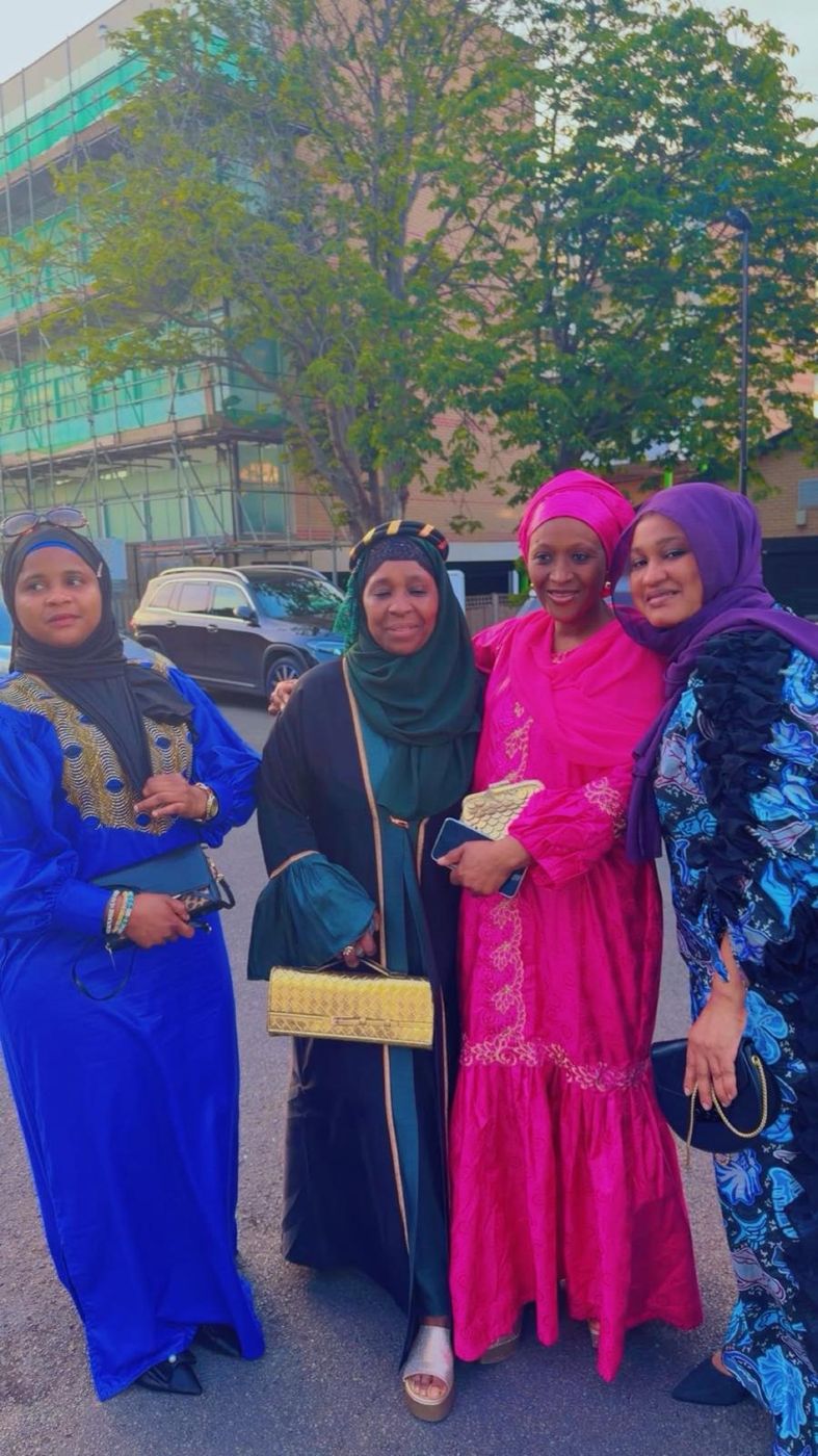 Four members in blue, pink and patterned gowns
