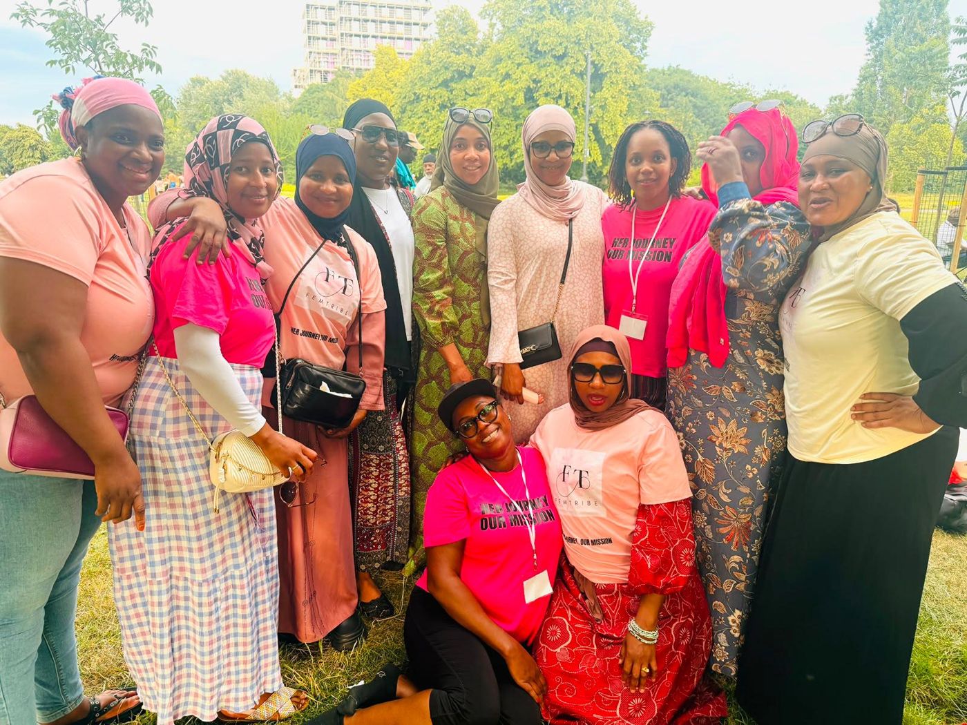 Members in matching pink tops gathered in a park